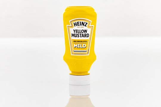 Heinz Yellow Mustard Mild squeeze bottle isolated on light background. Illustrative editorial studio product photography of packaged condiment for grocery and fast food concepts.