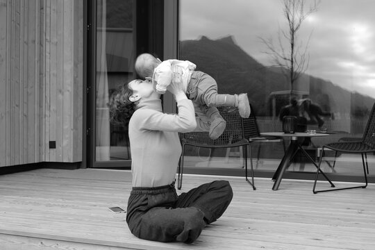 Happy young mother with a child outside their house 