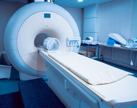 Modern MRI machine in a clean medical imaging room with examination table and equipment