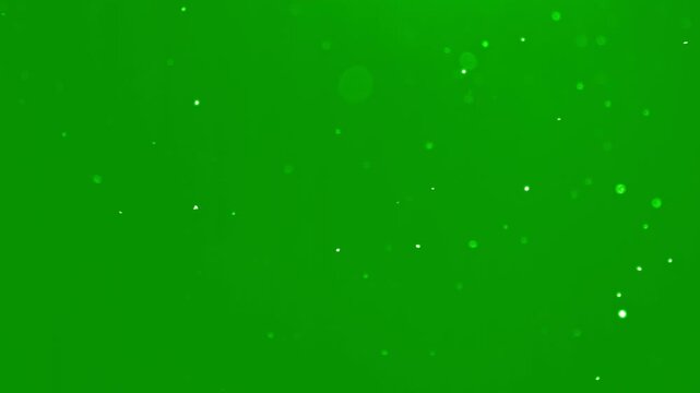 Beautiful slow motion snow dust with soft light particles on a green background. Perfect for Christmas visual, winter intro, cinematic overlay, motion design project. White snowflakes falling isolated