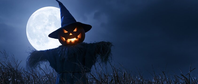 Eerie Scarecrow under a Full Moon. Scarecrow with the head of a halloween pumpkin in a field with full moon in the sky.