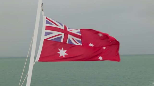 Australian Red Ensign Flag Blowing in Strong Wind on Moving Ferry