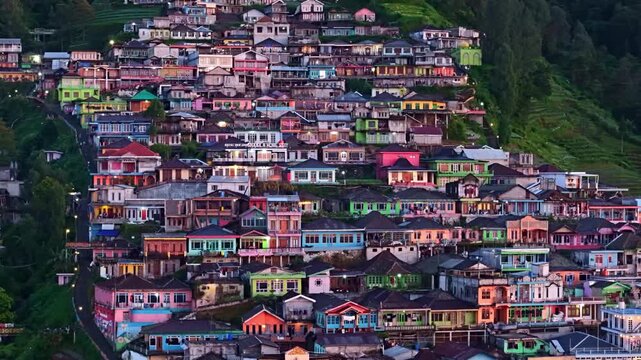 aerial view of Nepal van Java village at dawn, colorful hillside houses with soft blue light on Mount Sumbing slope.