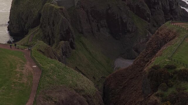 Aerial revealing view of dunnottar castle ruins on a cliff top in scotland