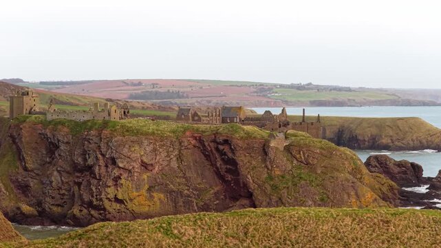 Dramatic dunnottar castle perched on a cliff overlooking the sea in scotland
