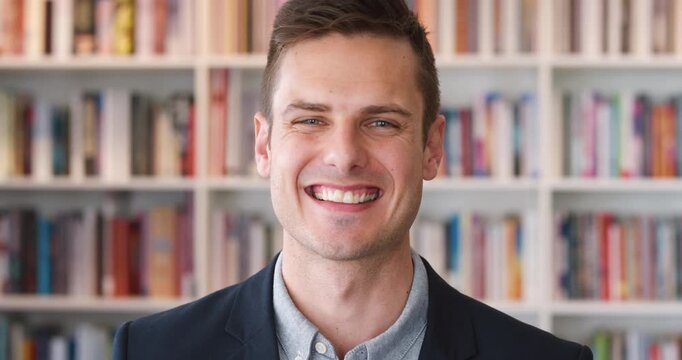 Face, laughing and man in library for education, university professor and confidence for teaching. Portrait, pride or literature educator with research for English lecture, knowledge sharing or smile