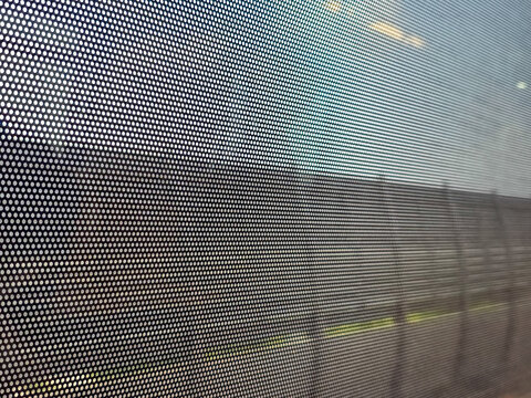 Close up abstract background view through window mesh screen pattern looking out at blurred landscape feeling calm and contemplative