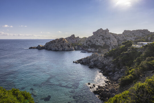 View of the granite rock formations and turquoise sea at Capo Testa with Mediterranean scrub under a bright sky Capo Testa, Cala Spinosa, Sardegna, Italy.