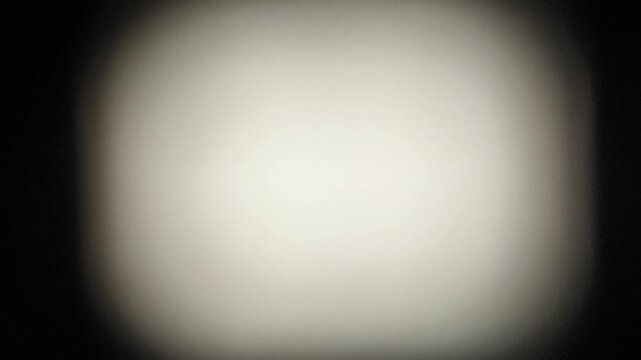 Faded and blurry abstract black background texture with grey, white, chrome or silver color center for copy space. Retro vintage style 80s or 90s vibe graphic design background with shaky motion.