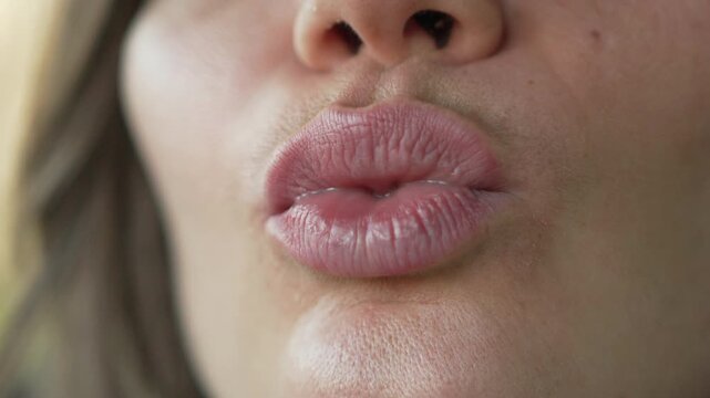 Lips mouth woman making pouting expressions and kissing gestures in an extreme close up shot with natural lighting