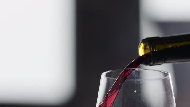 Slow motion pour red wine in dusty glass closeup