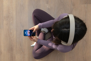 Naklejka premium Woman meditating with headphones and phone for mindfulness