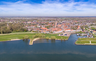 Obraz premium Aerial view of historic Wijk bij Duurstede with red roofs, Lek river, dyke road and harbor with traditional Dutch windmill, Utrecht, Netherlands