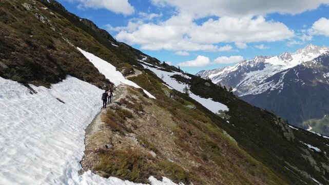 Hikers climbing a snow covered alpine slope near Lac Blanc in Chamonix, France, captured in slow motion