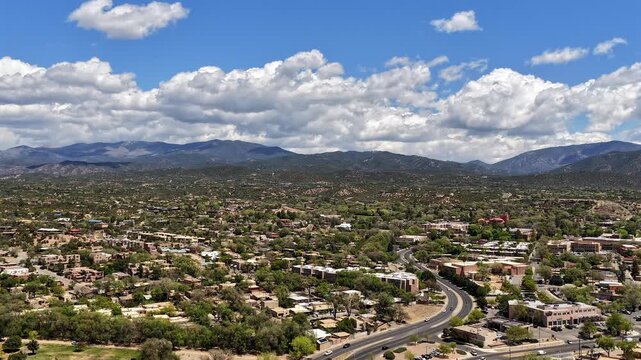 4K drone timelapse captures shifting spring clouds and dynamic light over Upper Santa Fe New Mexico. Cinematic aerial view features the Sangre de Cristo foothills and southwestern mountain scenery.