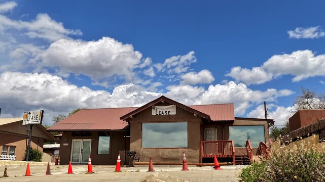 4K drone timelapse captures a quirky vacant building with windows reflecting surreal cloud movement. Cinematic aerial view highlights abstract architecture, shifting desert light, and skyscapes.