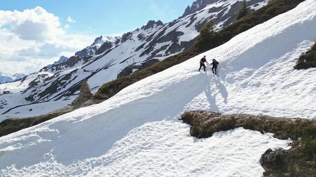 Snow hikers crossing a scenic alpine trail near Lac Blanc in Chamonix, France, surrounded by snowy peaks and dramatic mountain landscapes in the French Alps.
