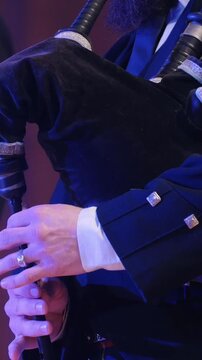 Bagpipe player plays musical instrument at the stage