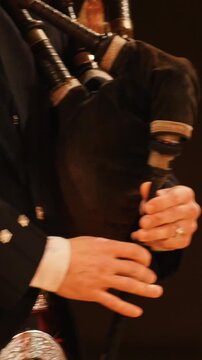 Bagpipe player plays musical instrument at the stage