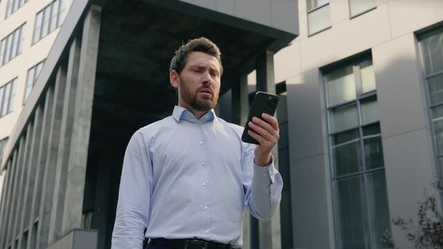 Upset Caucasian businessman reading mobile phone office in city sad stressed male entrepreneur receiving bad news message rejection adult business man bank notification job loss anxiety headache urban