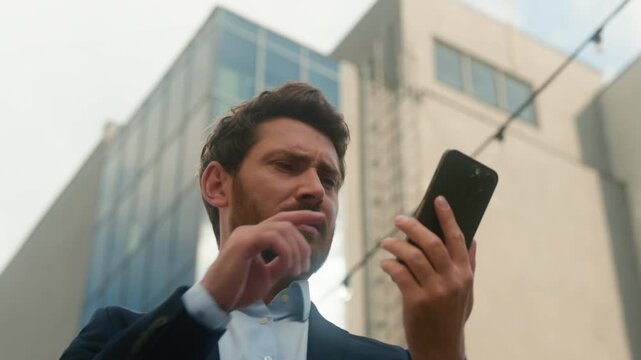 Caucasian middle aged business man searching mobile signal in sunny city downtown frustrated businessman raising phone high bad connection problem trying call find WiFi network employer male outdoors