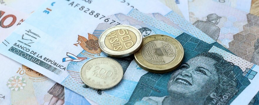 Colombian peso money bills and coins on table. Colombia cash of COP currency close up