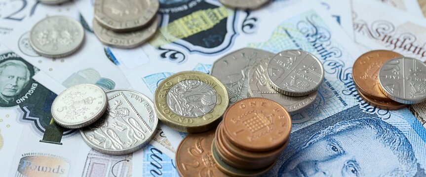 British pound money bills and coins on table. United Kingdom cash of GBP currency close up