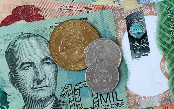 Costa Rican colon money bills and coins on table. Costa Rica cash of CRC currency close up
