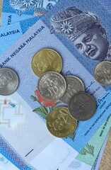 Malaysian ringgit money bills and coins on table. Malaysia cash of MYR currency close up © Larysa