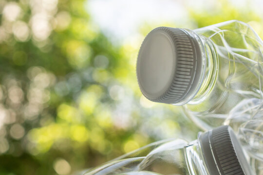 crushed plastic bottles on green bokeh nature background, recycling and zero waste concept