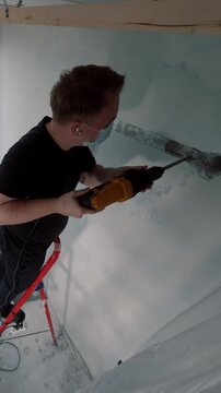 Technician using wall chaser during air conditioner installation