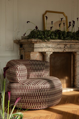 Obraz premium Elegant Living Space with Modern Armchair and Marble Fireplace Adorned with Dark Calla Lilies and Gold Mirror