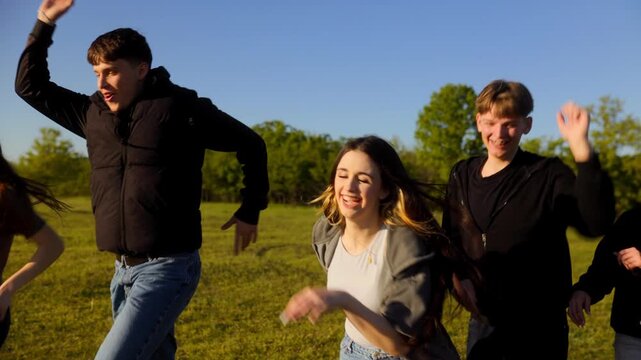 Five joyful friends skipping and running through a rural meadow field