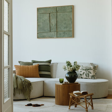Stylish and botanical interior of tenement house with mock up paintings and modern furniture. 