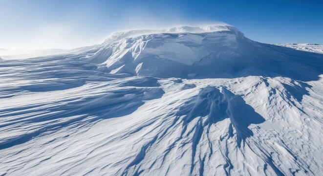 Massive, sculpted snowdrift covering the ground completely after a severe winter storm, showing textures and deep shadows under bright light, weather, background, scenic