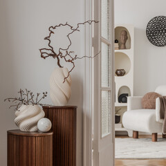 Pair of fluted wood pedestals with organic vases and natural branches in a bright hallway. © FollowTheFlow