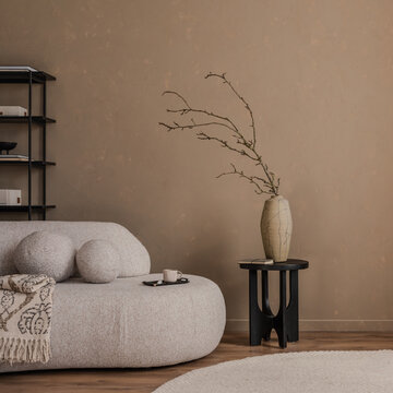 Minimalist beige interior with modern furniture, a ceramic vase on a black table, and a soft round rug, styled with natural textures and warm neutral tones.