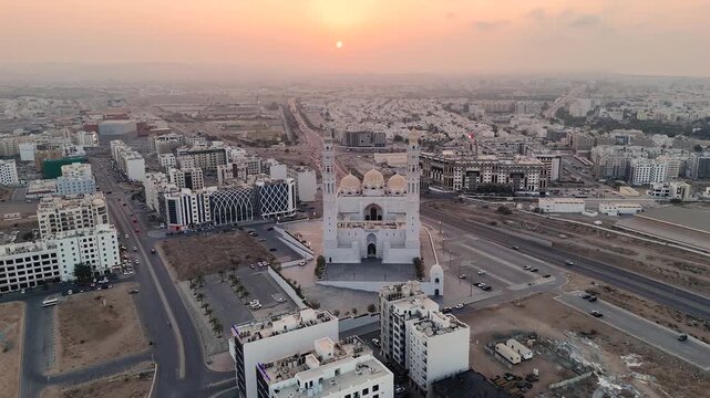 Muscat, Oman. Aerial drone view at sunset of the capital of Oman. Flight over the Mohammed Al Amin Mosque at sunrise or sunset. Flight over the sleeping city in the morning light.