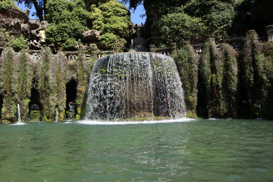 Splendida veduta della storica Fontana dell'Ovato con i suoi iconici giochi d'acqua a cascata e la lussureggiante vegetazione nei giardini rinascimentali di Villa d'Este a Tivoli, Italia.