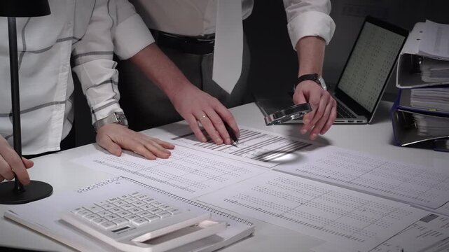 Business professionals analyzing financial documents, using magnifying glass for meticulous data review, focusing on audit, investigation, fraud detection, and regulatory compliance