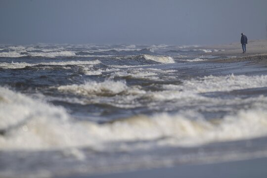 Man on the beach, surf, S&oslash;ndervig Strand, Ringk&oslash;bing Fjord, Denmark