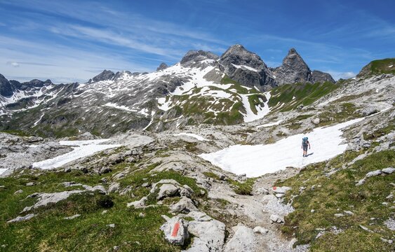 Hiker on hiking trail, in the background old snow fields and rocky peaks of M&auml;delegabel and Trettachspitze, mountain panorama, Heilbronner Weg, Allg&auml;u Alps, Allg&auml;u, Bavaria, Germany