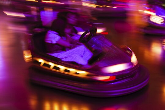 Couple driving bumper car at night, Oktoberfest, Munich, Upper Bavaria, Bavaria, Germany