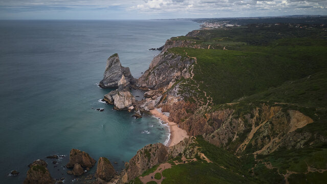 Aerial view of praia da ursa cliffs on a sunny day with clear sky. Cascais, Portugal