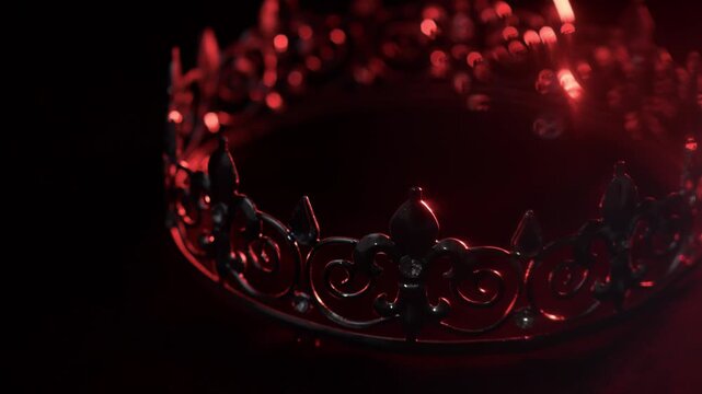 Golden crown with red light reflections on black background, luxury and power concept. . Sparkling reflections and rich contrast create a strong visual of power, authority and luxury. 