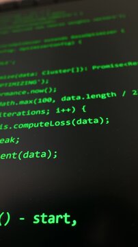 Bright green neural network script lines automatically generate on a dark monitor display. Concept of artificial intelligence coding, modern software development, and cyber security.