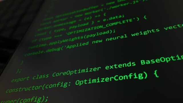 Glowing green lines of JavaScript programming source code are displayed on a dark computer monitor screen. Concept of software development, cyber security hacking, and data transformation.