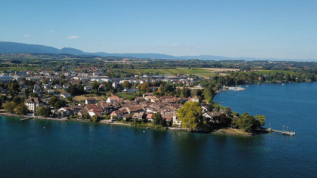 Aerial view of the historic lakeside town on the shores of Lake Geneva with red-roofed houses and lush greenery in Saint-Prex, Vaud, Switzerland.