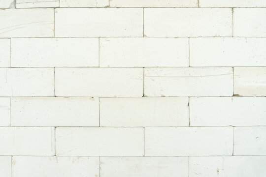 white wall constructed of lightweight concrete blocks. The wall has a uniform, minimalist aesthetic with visible mortar joints between the unpainted white blocks.