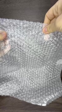 Hands Popping Bubble Wrap in a Relaxing Close-Up Shot